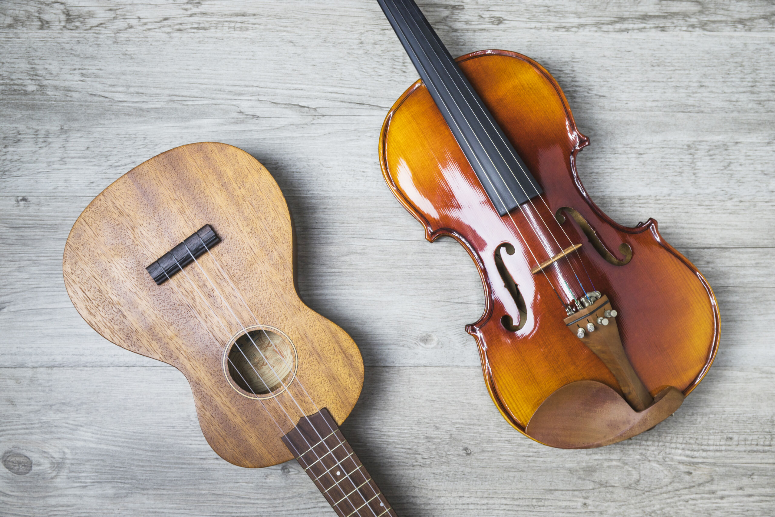 overhead-view-classical-guitar-violin-wooden-backdrop